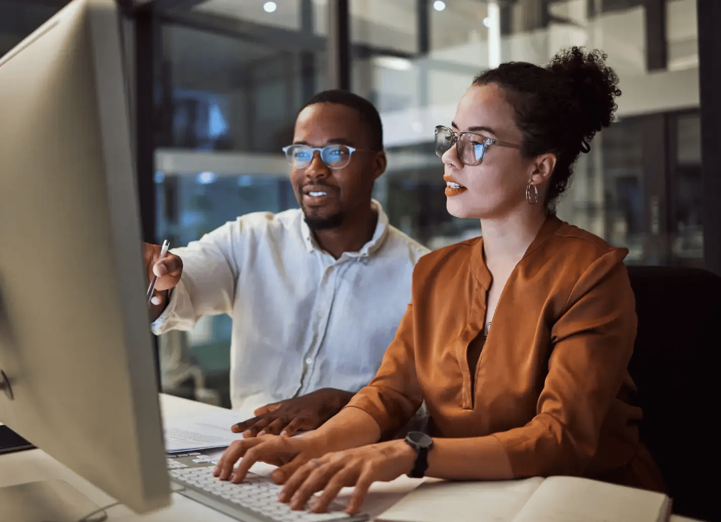 Man and woman working at screen at night
