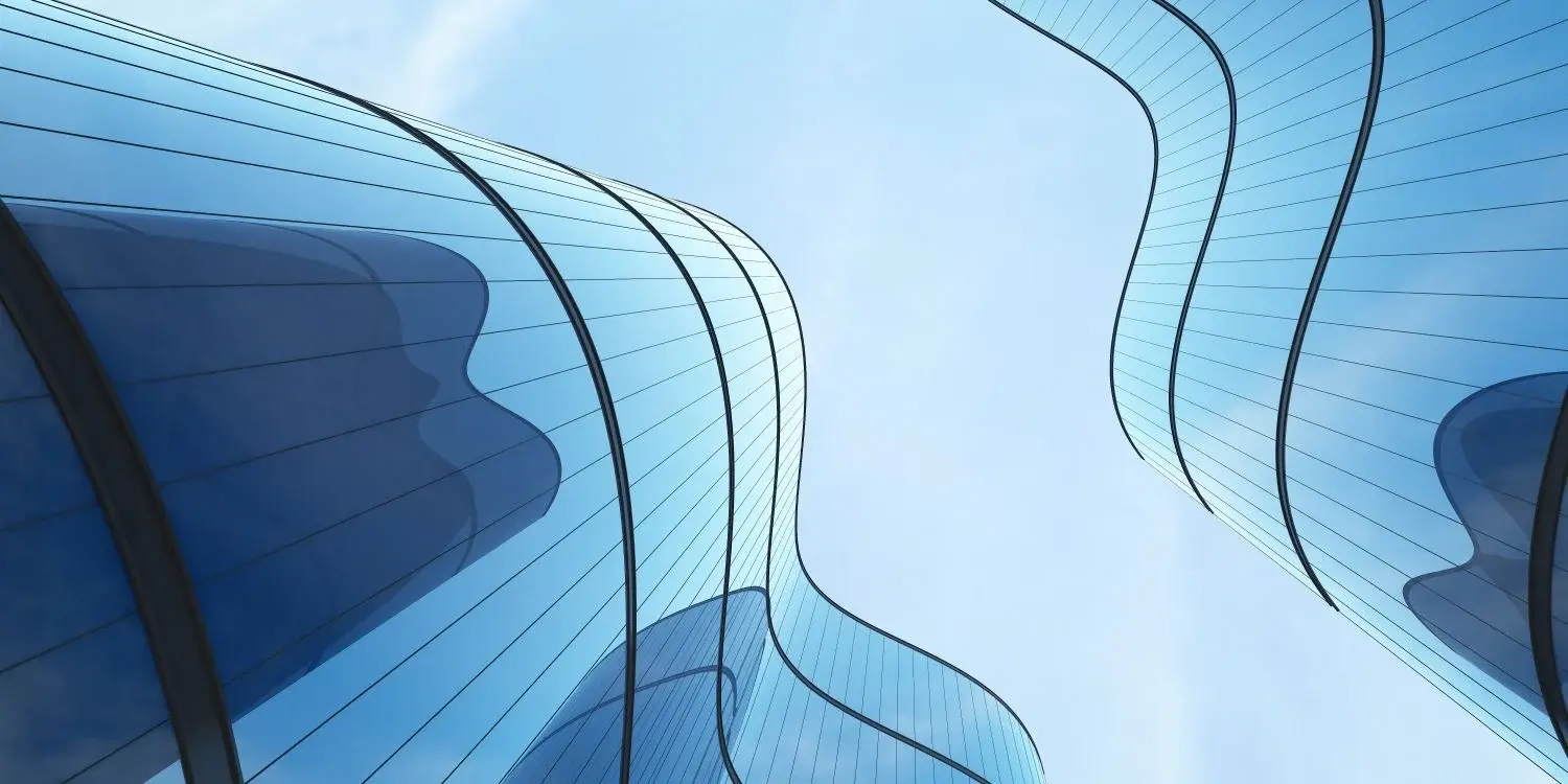 Skyward view of wavy modern buildings and blue sky