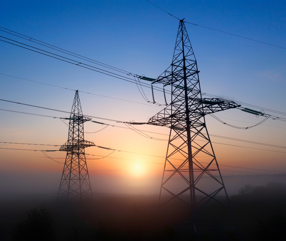 High-voltage electricity transmission towers at sunrise, representing energy infrastructure and digital transformation.